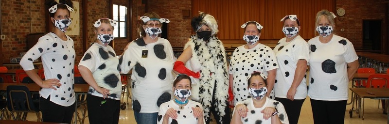Teachers dressed up like 101 Dalmatians and Cruella